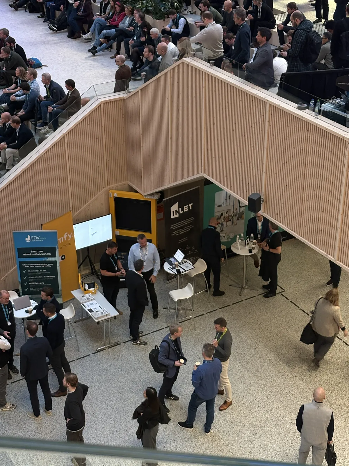 The Awaio stand seen from the balcony above, with visitors on the expo floor